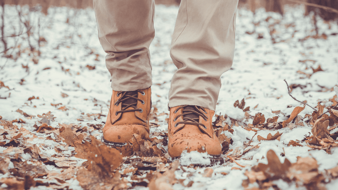 Brauner Winterschuhe auf Laub mit Frost